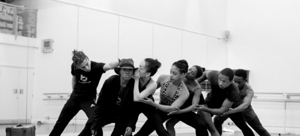 Ballet dancers in rehearsal. The dancers, who are all Black, are moving together.