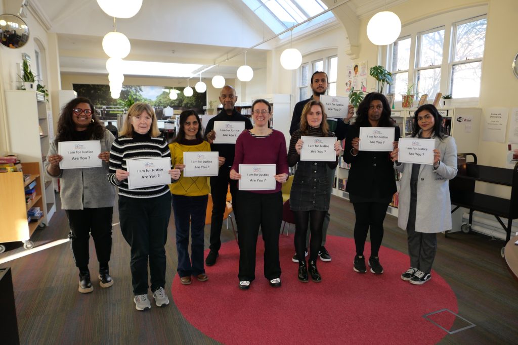 Group of people at Ealing Law Centre. They are holding signs which say 'I am for justice, are you?'