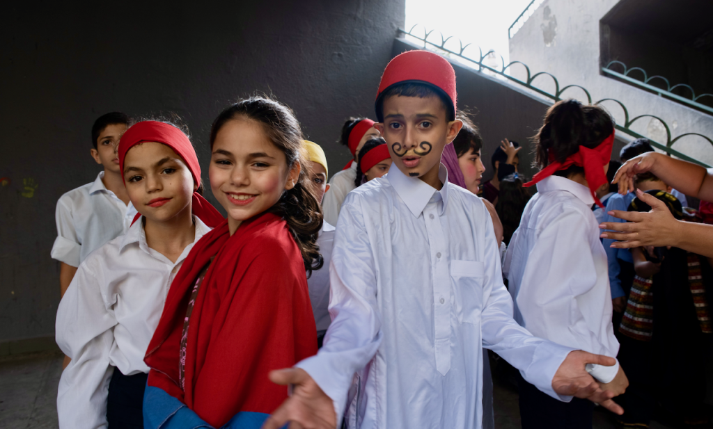 Children performing a play - they are in costumes and smiling.